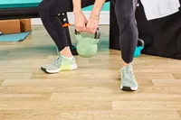 Person squatting wearing Nike Women's Metcon 9