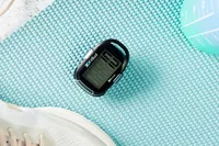 The 3DActive 3DFitBud Simple Step Counter sitting on a yoga mat