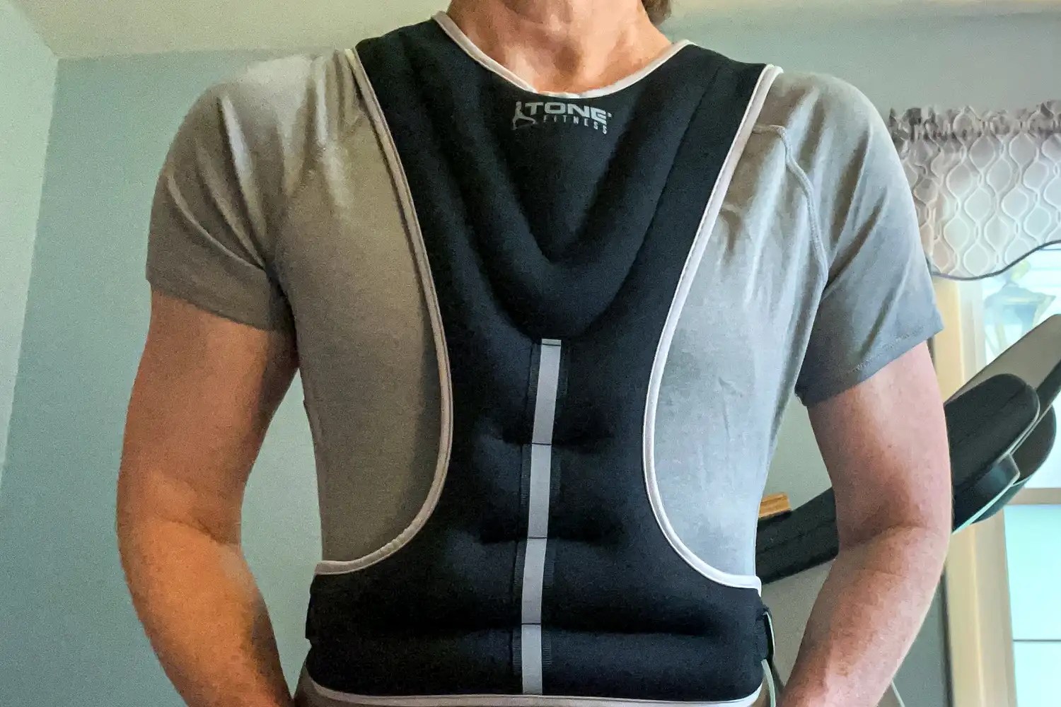 The front of a person wearing the Tone Fitness HHWV-TN Weighted Vest
