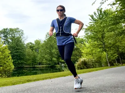 A person runs outside while wearing the Tone Fitness HHWV-TN Weighted Vest