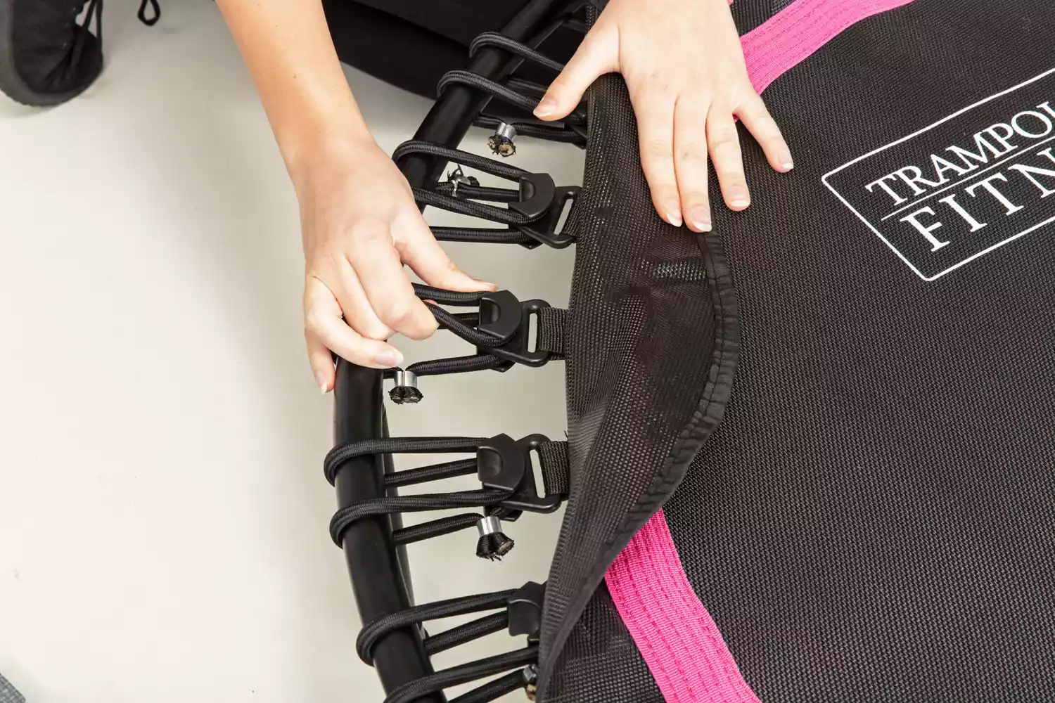 Person holding spring strap on a DARCHEN Rebounder Mini Trampoline
