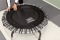 Person lifting up the outer seam of a JumpSport 350 Indoor Fitness Trampoline 