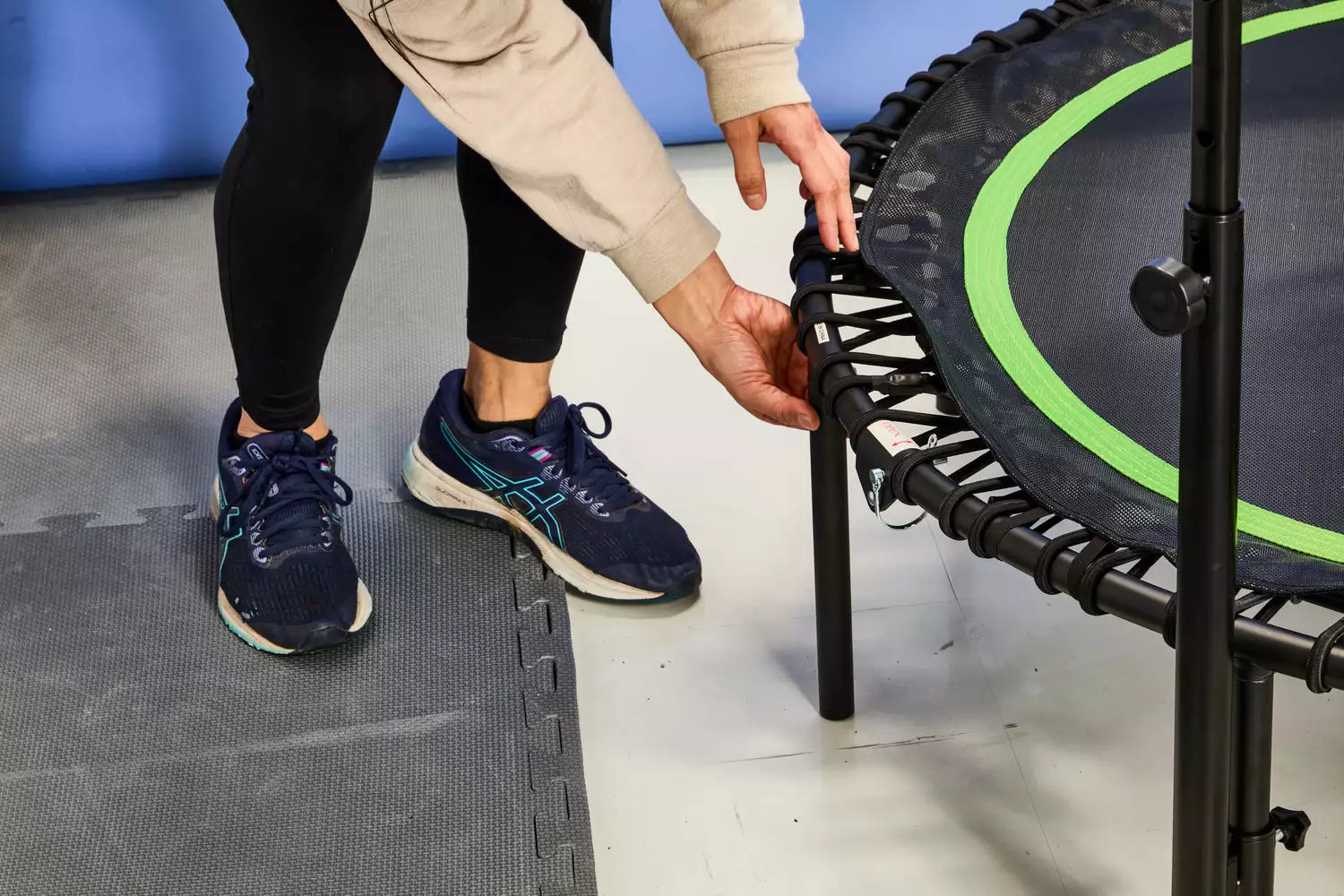 A person touching the strings on the BCAN 450/550 Lbs Foldable Mini Trampoline
