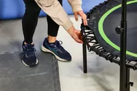 A person touching the strings on the BCAN 450/550 Lbs Foldable Mini Trampoline