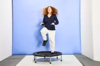 A person jumping with one knee up on the Fitness Gear Mini Trampoline