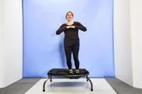 A person jumping to the side of the Sunny Health & Fitness 36 Inch Indoor & Outdoor Exercise Trampoline