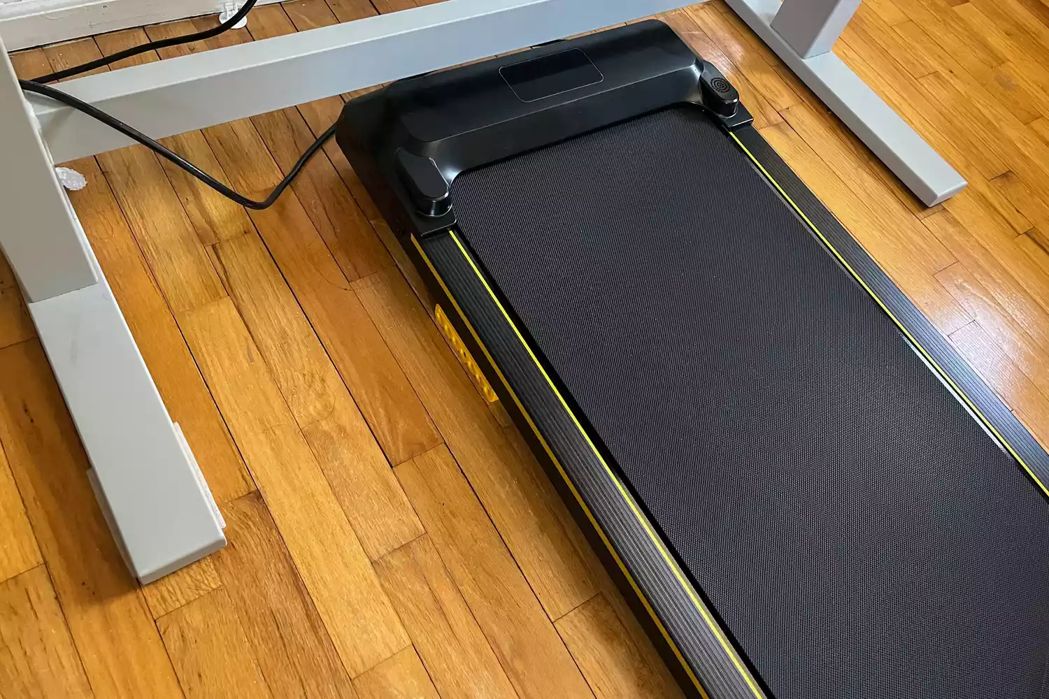 The UREVO Walking Pad Under Desk Treadmill on a wooden floor
