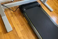 The UREVO Walking Pad Under Desk Treadmill on a wooden floor