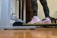 A person walks on the UREVO Walking Pad Under Desk Treadmill