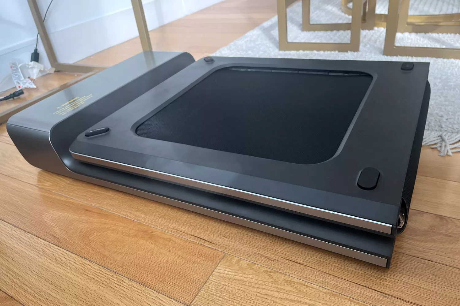 WalkingPad P1 Foldable Walking Treadmill on wood floor near rug and chairs