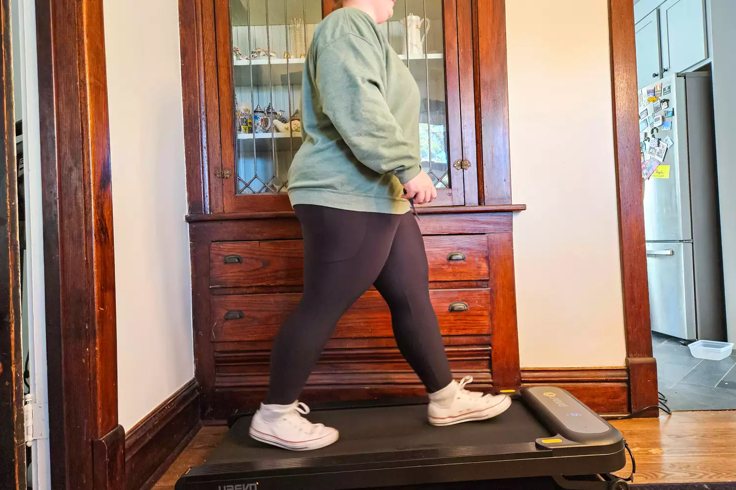 A person walks on the Urevo SpaceWalk 3S Treadmill