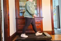 A person walks on the Urevo SpaceWalk 3S Treadmill