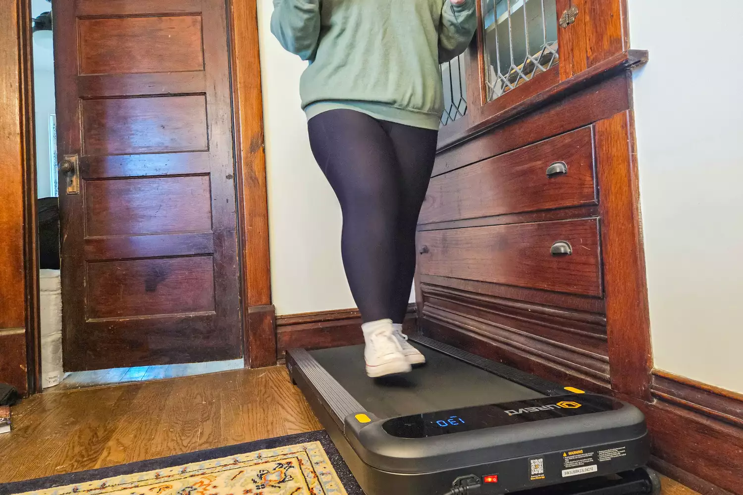 A person walks on the Urevo SpaceWalk 3S Treadmill