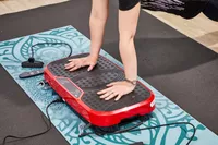 A person does a pushup on the Hurtle Fitness Vibration Platform Machine