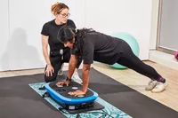 A person does a pushup on the LifePro Rumblex Plus 4D Vibration Plate Exercise Machine