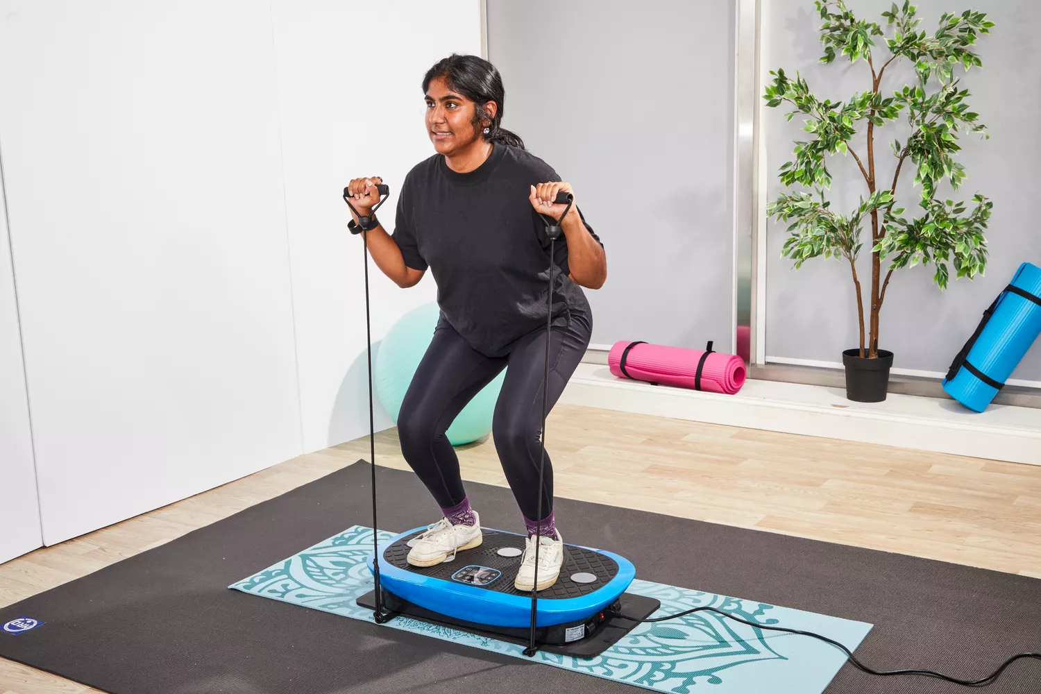 A person stands on the LifePro Rumblex Plus 4D Vibration Plate Exercise Machine
