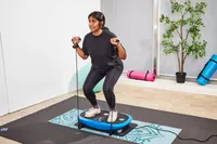A person stands on the LifePro Rumblex Plus 4D Vibration Plate Exercise Machine