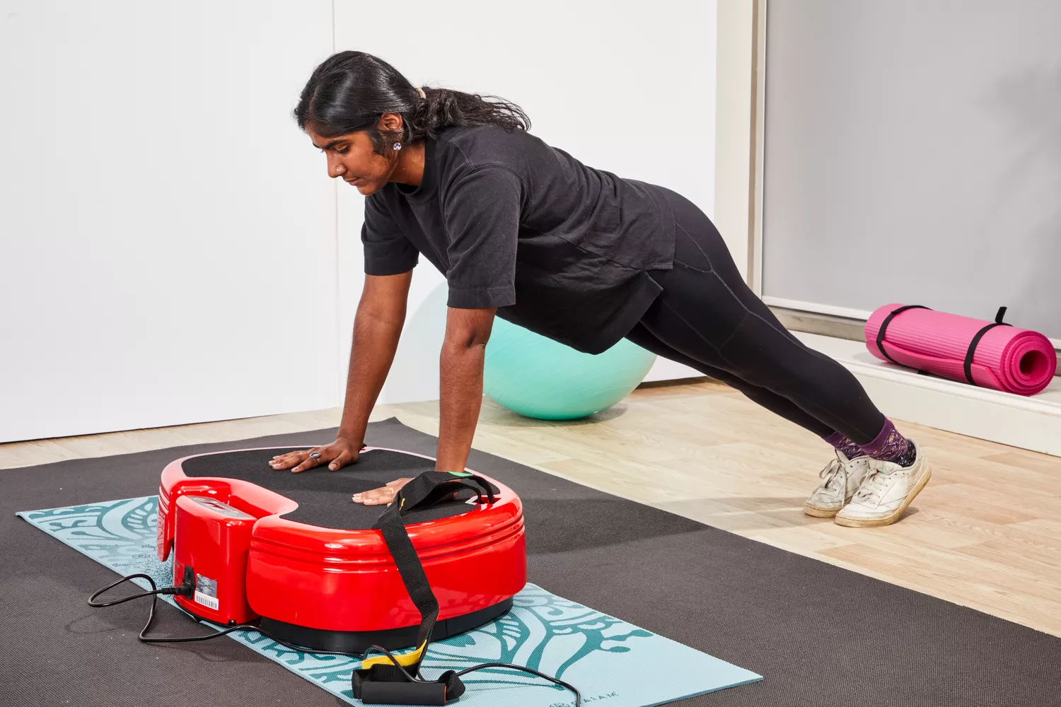 A person does pushups on the Power Plate MOVE Vibrating Plate