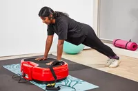 A person does pushups on the Power Plate MOVE Vibrating Plate