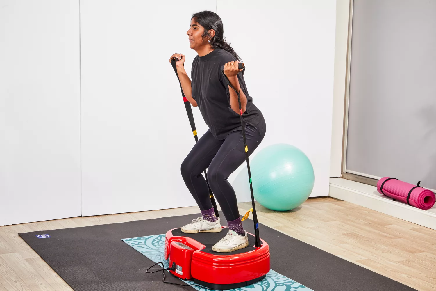 A person uses the resistance bands on the Power Plate MOVE Vibrating Plate