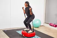 A person uses the resistance bands on the Power Plate MOVE Vibrating Plate