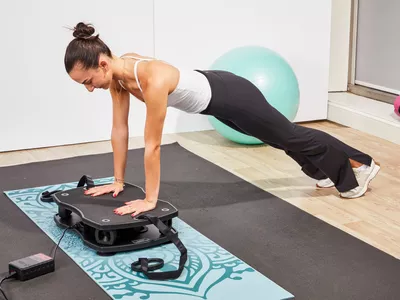 A person does a pushup on the VT Vibration Therapeutic Frequency Vibration Plate