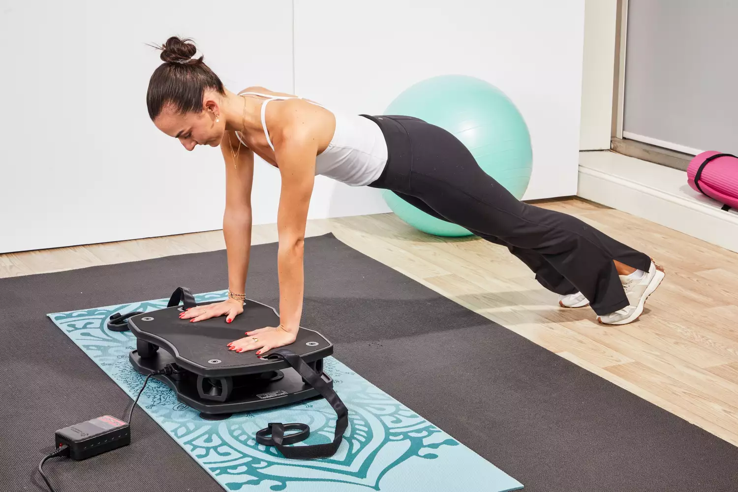 A person does a pushup on the VT Vibration Therapeutic Frequency Vibration Plate