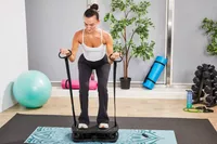 A person pulls the resistance bands on the VT Vibration Therapeutic Frequency Vibration Plate