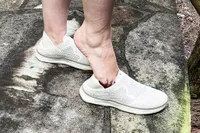 A person places their foot into the Vionic Women's Sage RX Recovery Slip-On Shoes