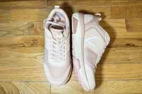 A pair of Vionic Women's Walk Strider Sneakers on a wooden floor