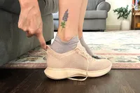 A person uses the heel tab to put on the Vivaia Unisex Urban Sneaker Sliders