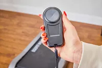 A hand holding the remote to the Egofit Walker Pro-M1 Treadmill