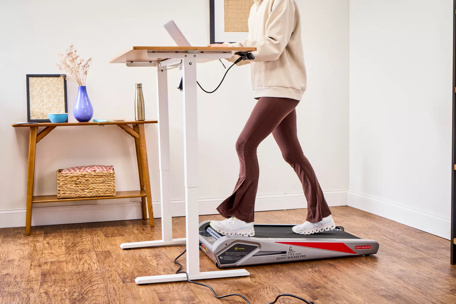 A person using a laptop while walking on the Egofit Walker Pro-M1 Treadmill