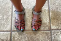 Person wearing Teva Women's Tirra Sandals on a tile floor