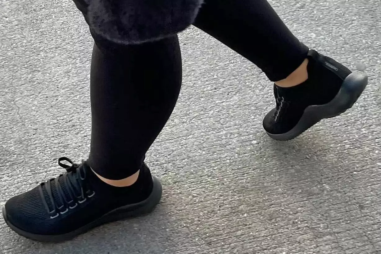 A person walks outside while wearing the Aetrex Carly Arch Support Sneakers