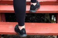 A person walks up steps while wearing the Aetrex Carly Arch Support Sneakers