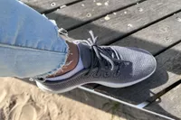 A close-up of a Allbirds Tree Runner worn on a wooden deck