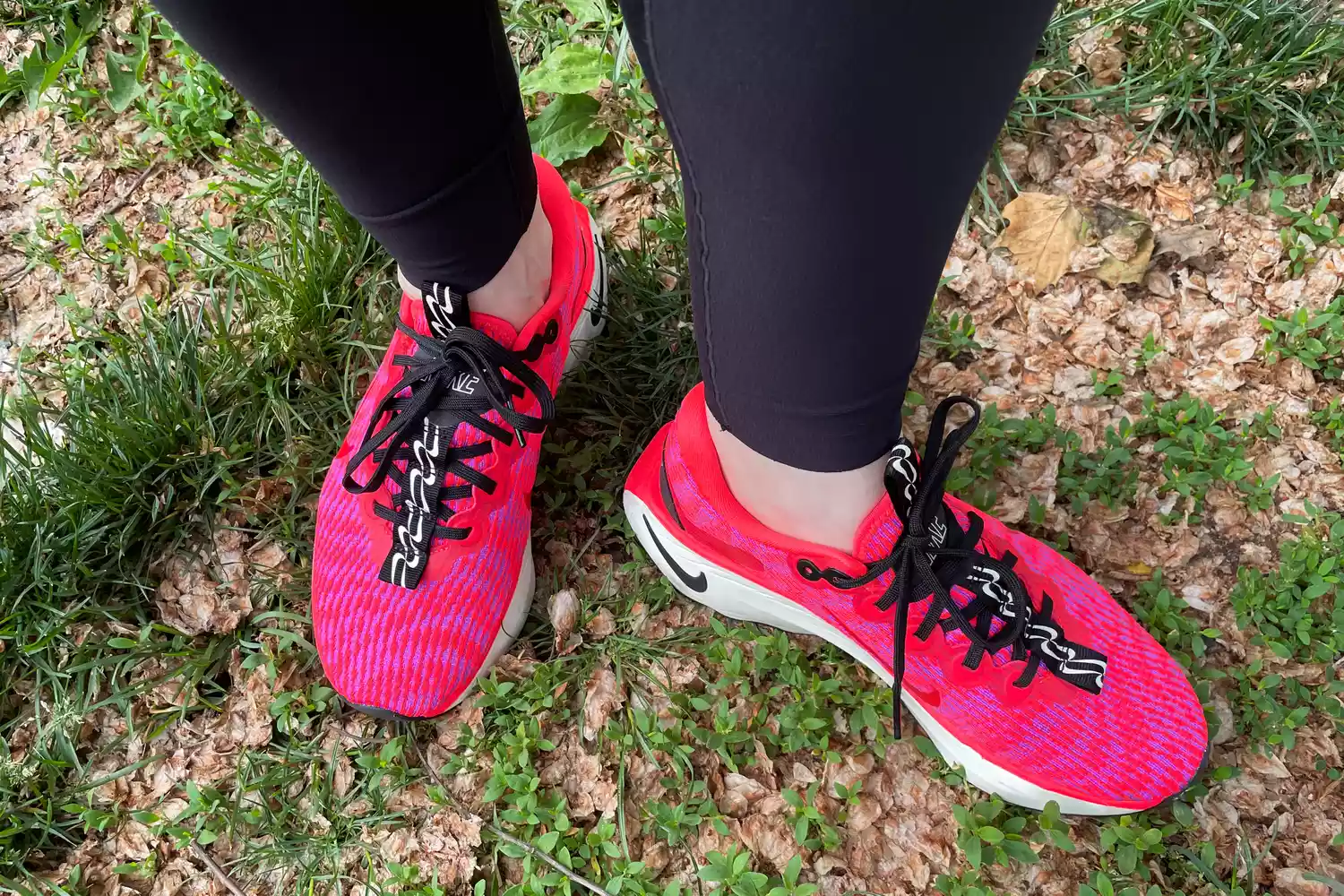 Feet wearing Nike Motiva Women's Walking Shoes on grass