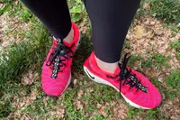 Feet wearing Nike Motiva Women's Walking Shoes on grass