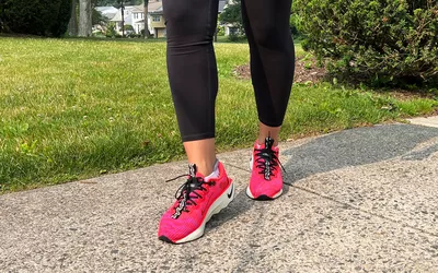 Feet wearing Nike Motiva Women's Walking Shoes on pavement