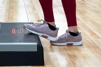 Person wearing Orthofeet Women's Kita Hands-Free Athletic Sneakers while stepping up on an exercise step