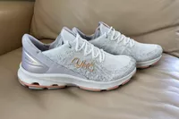 Ryka Devotion X Walking Shoes displayed on a leather sofa