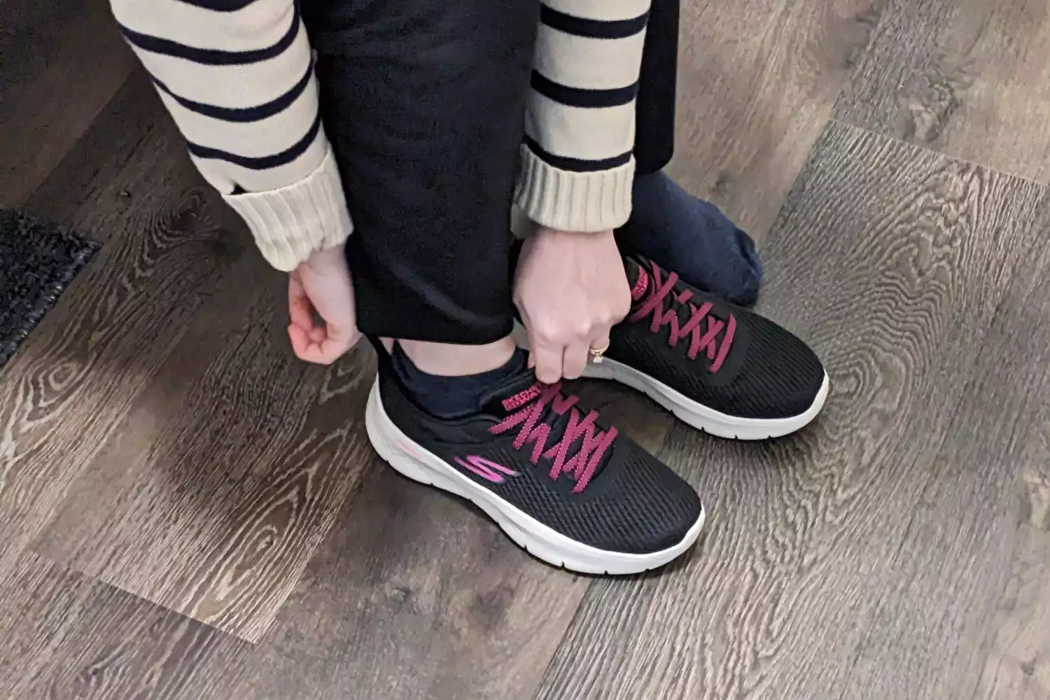 A person putting on a Skechers Go Walk Flex Alani Walking Shoe 