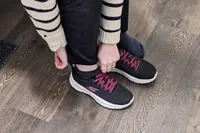 A person putting on a Skechers Go Walk Flex Alani Walking Shoe 