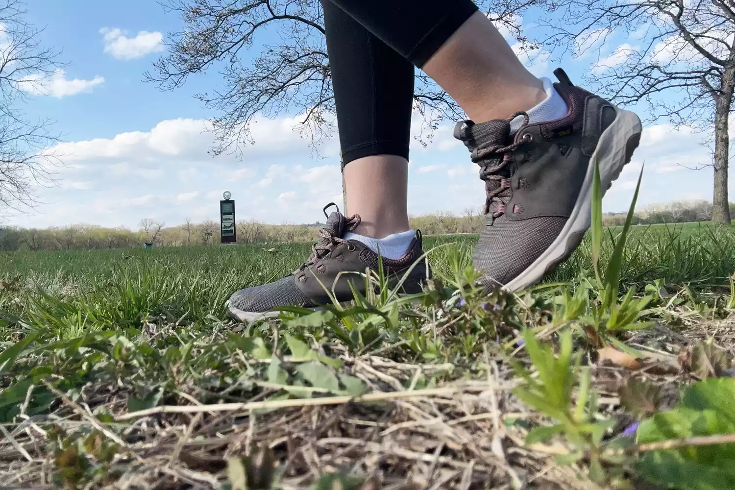 Feet wearing Teva Canyonview Women's Waterproof Hiking Shoes while walking on grass