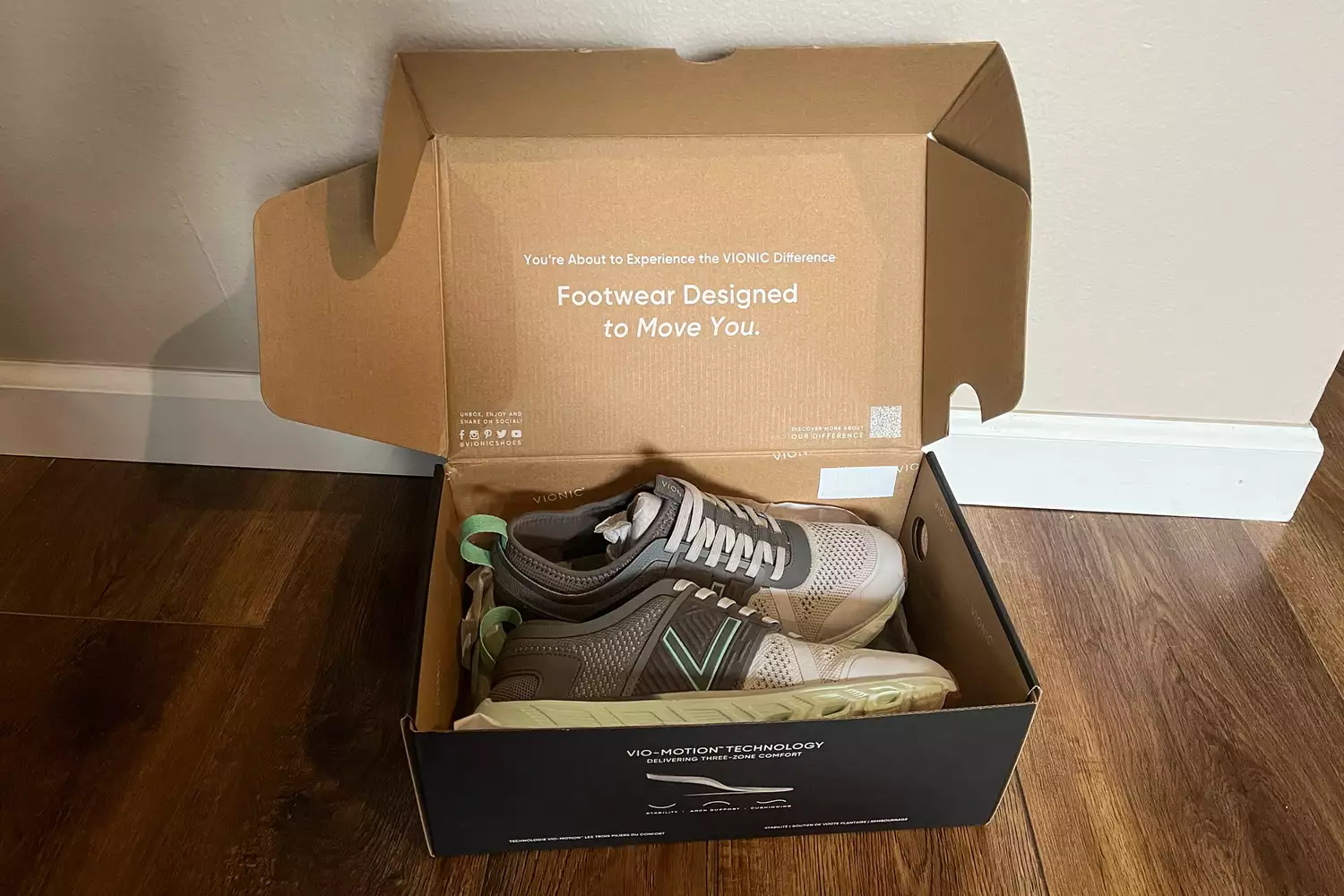 The Vionic Captivate sneakers in their box on a wooden floor