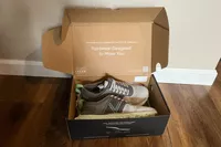 The Vionic Captivate sneakers in their box on a wooden floor