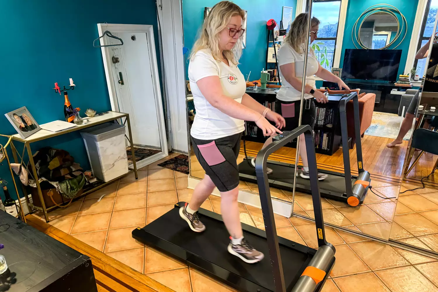 A person presses a button on the WalkingPad MC11 Workout Treadmill