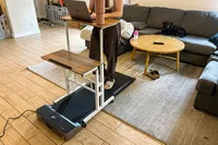 A person walks on the WalkingPad Z1 Folding Under Desk Treadmill while typing on a laptop