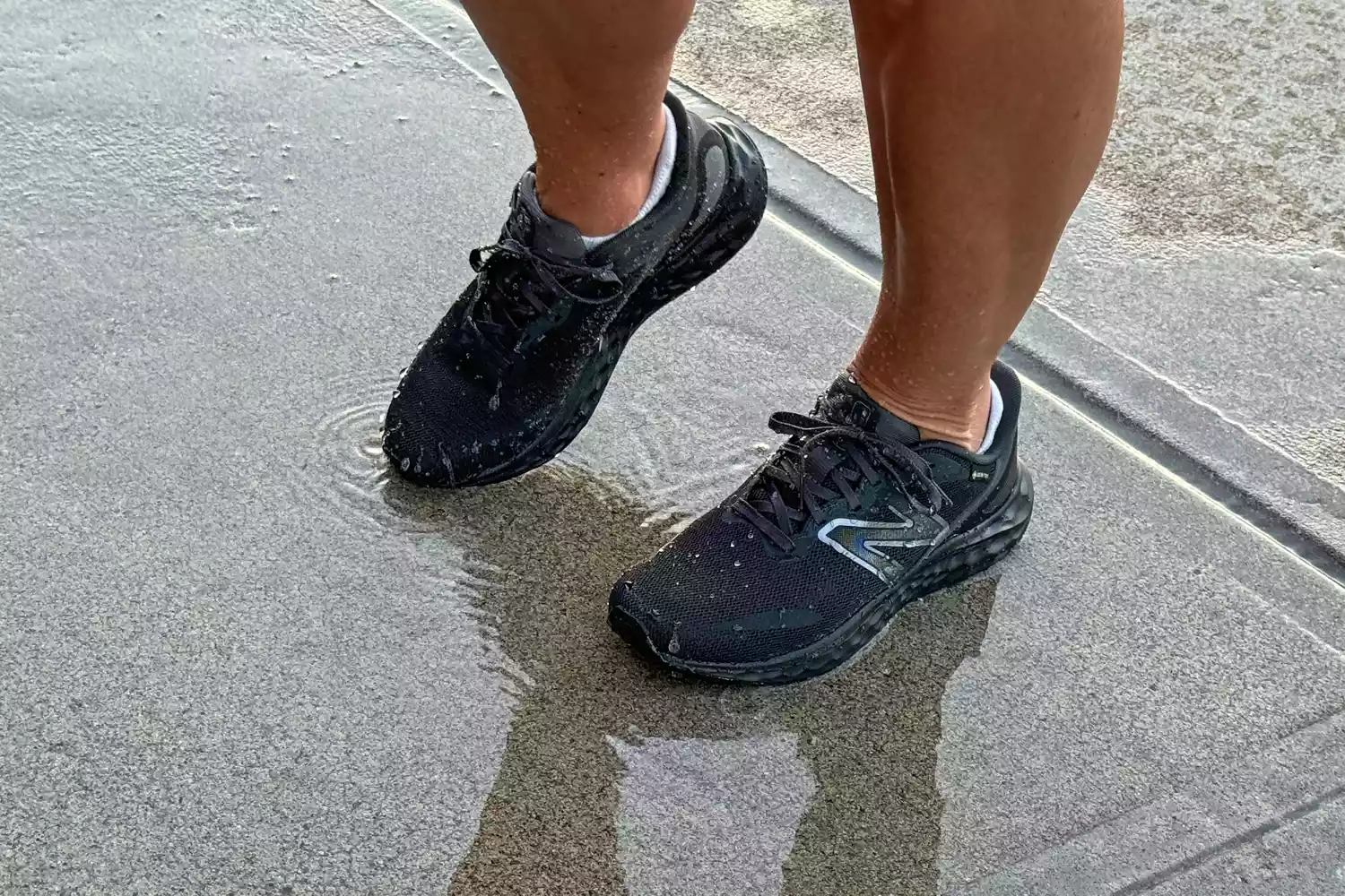 A person walks on concrete while wearing the New Balance Women's Fresh Foam Arishi v4 GTX Running Shoes